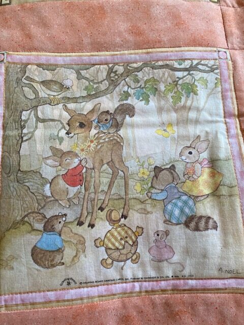 Machine-quilted baby quilt with woodland creature scenes, close-up of one scene
