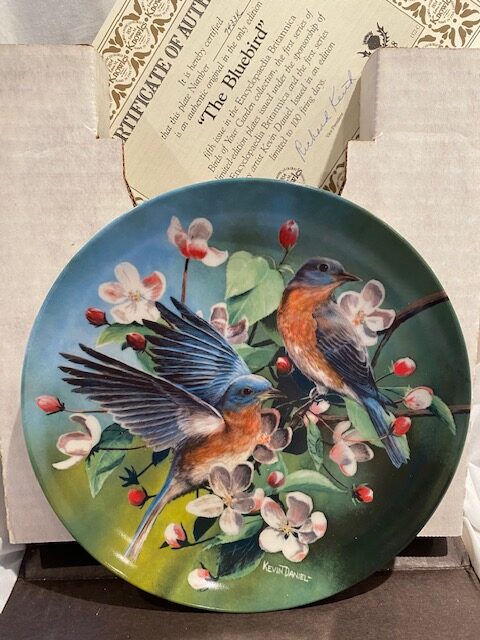 front of a collector plate - showing two bluebirds among small whish-pink flowers