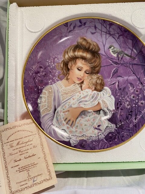 front of a collector plate - showing woman with a baby in her arms, a mockingbird on a branch in the background, against a purple background